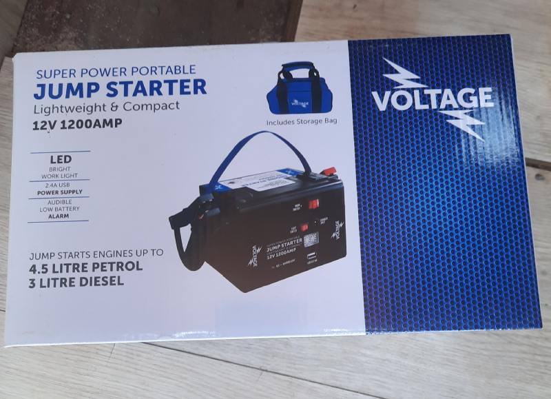 Voltage jump starter box, black and blue, labeled 12V 12000mAh compact lithium power bank with LED light.