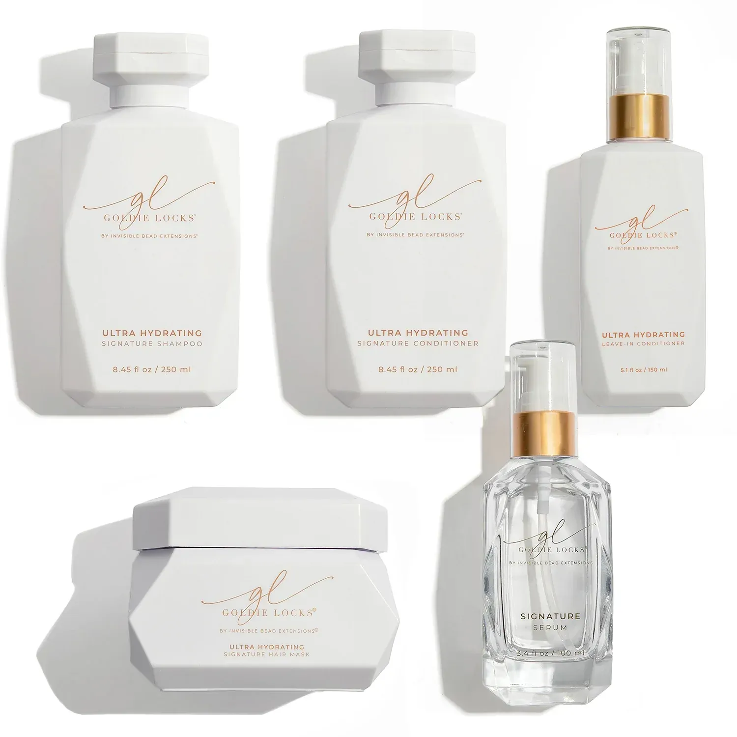 White luxury skincare bottles and jars with gold accents arranged on a light background