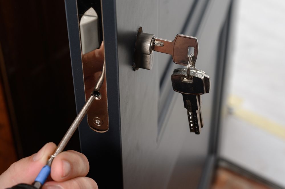 Person Using Screwdriver to Install Door Lock — Lake Macquarie Mobile Locksmiths in Warners Bay, NSW