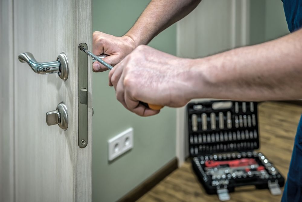 Person Using Screwdriver to Repair a Door Lock — Lake Macquarie Mobile Locksmiths in Kotara, NSW