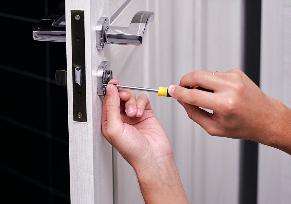 Man Fixing Lock with Screwdriver — Lake Macquarie Mobile Locksmiths in Blacksmiths, NSW