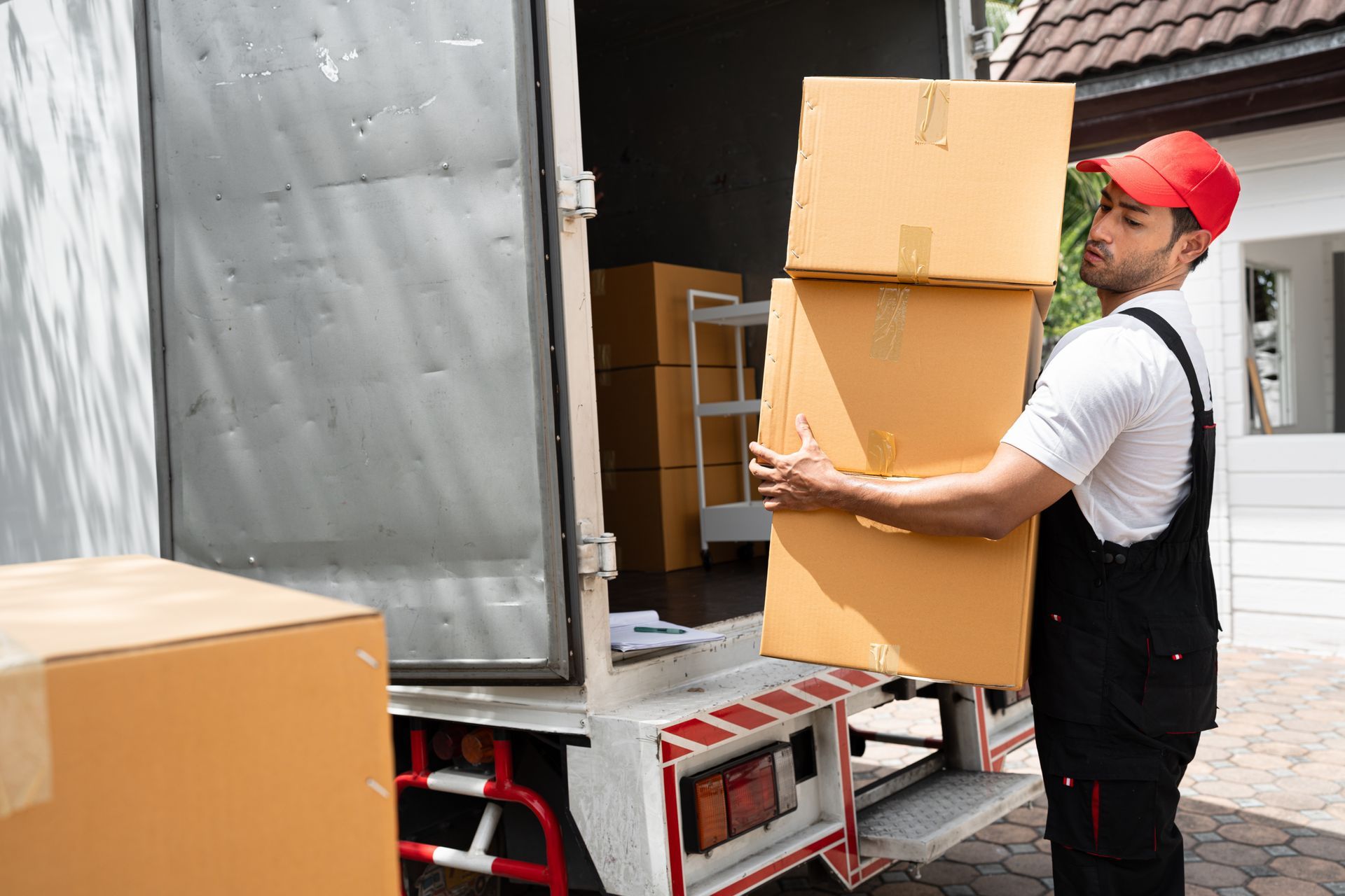 Man in Uniform Carries Boxes From a Moving Truck Into a Building — Johnny Farming Company In Ooralea, QLD