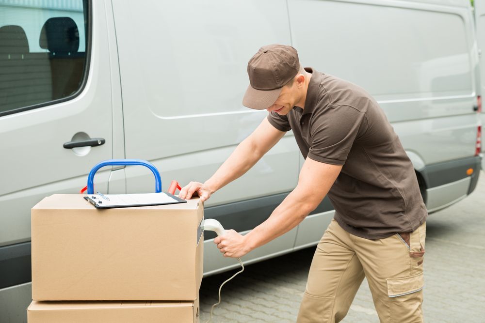 Delivery Person Scans a Package Next to a Van — Johnny Farming Company In Ooralea, QLD