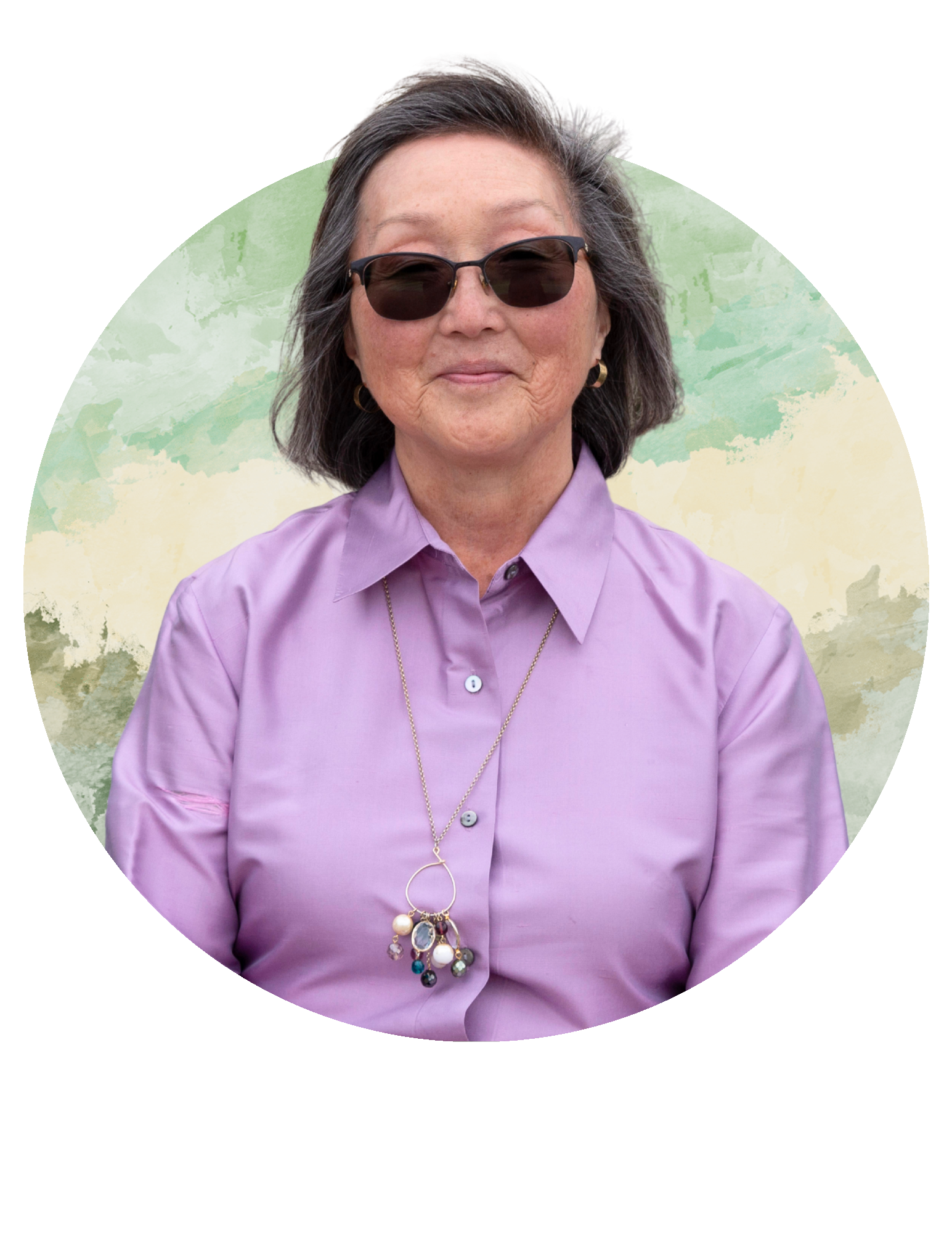 Woman in sunglasses and a lavender shirt standing before a circular pastel mural.
