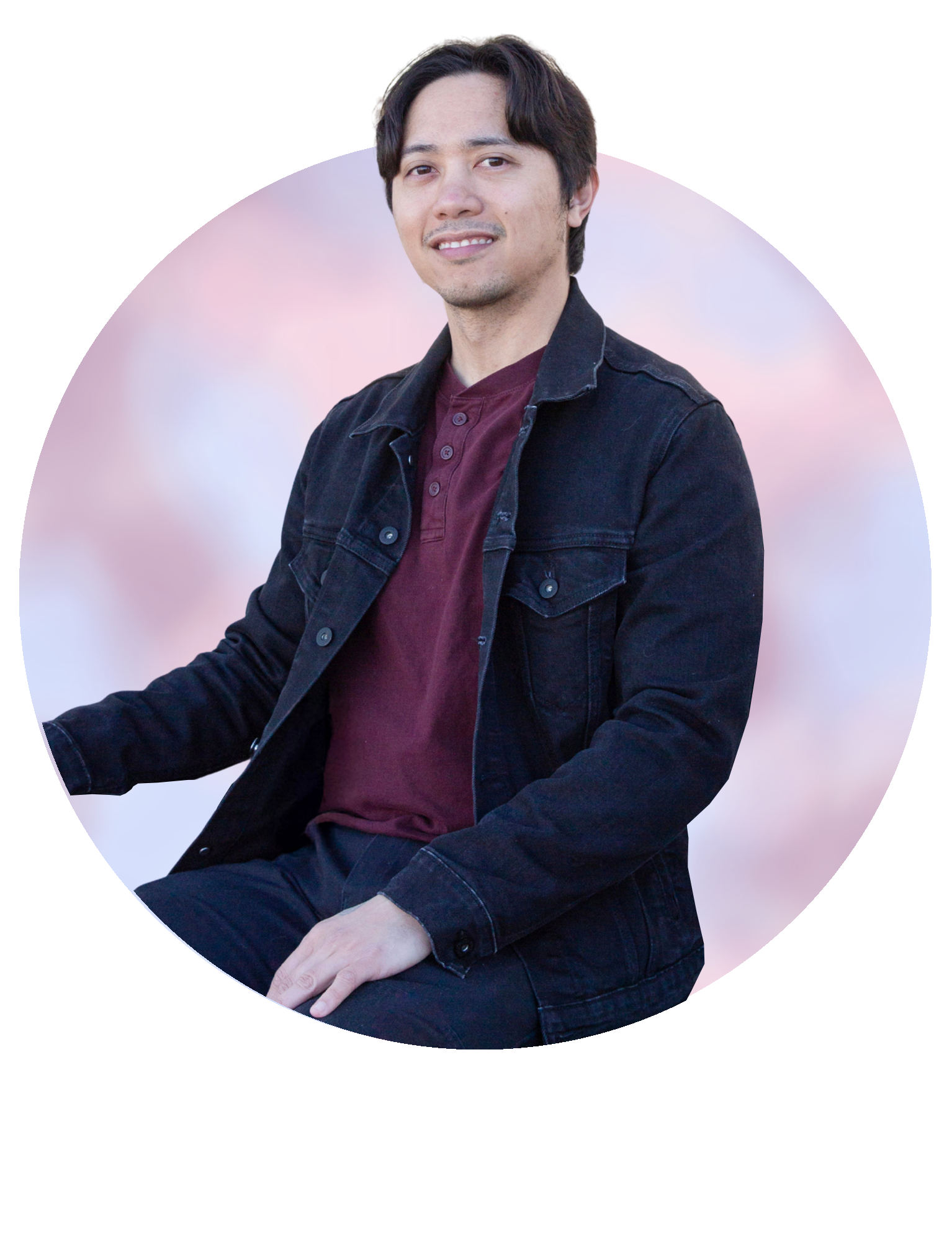 Portrait of a seated person in a dark jacket and maroon shirt against a soft pastel background