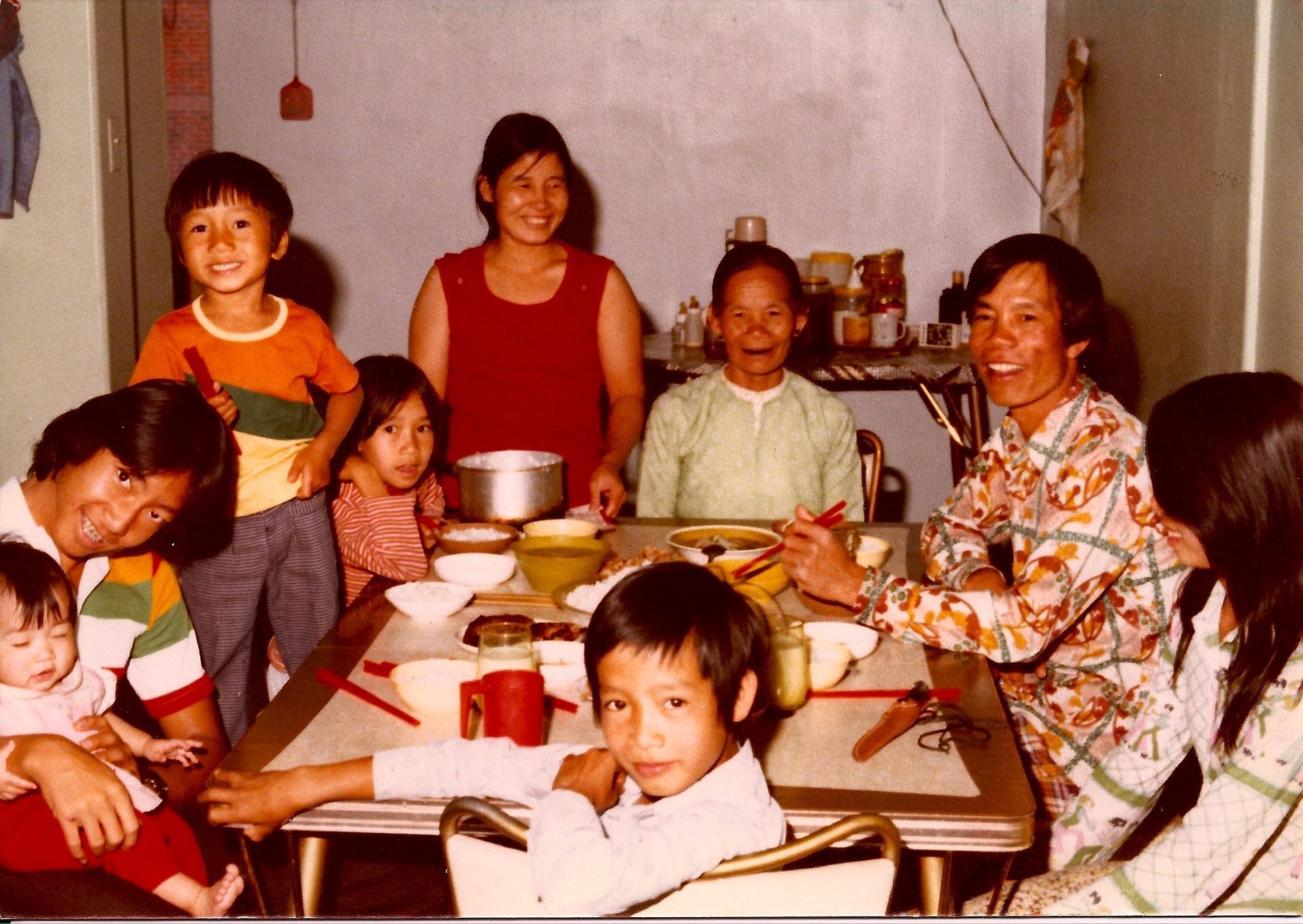 Group gathered around a dining table, smiling and sharing a meal in a cozy room.