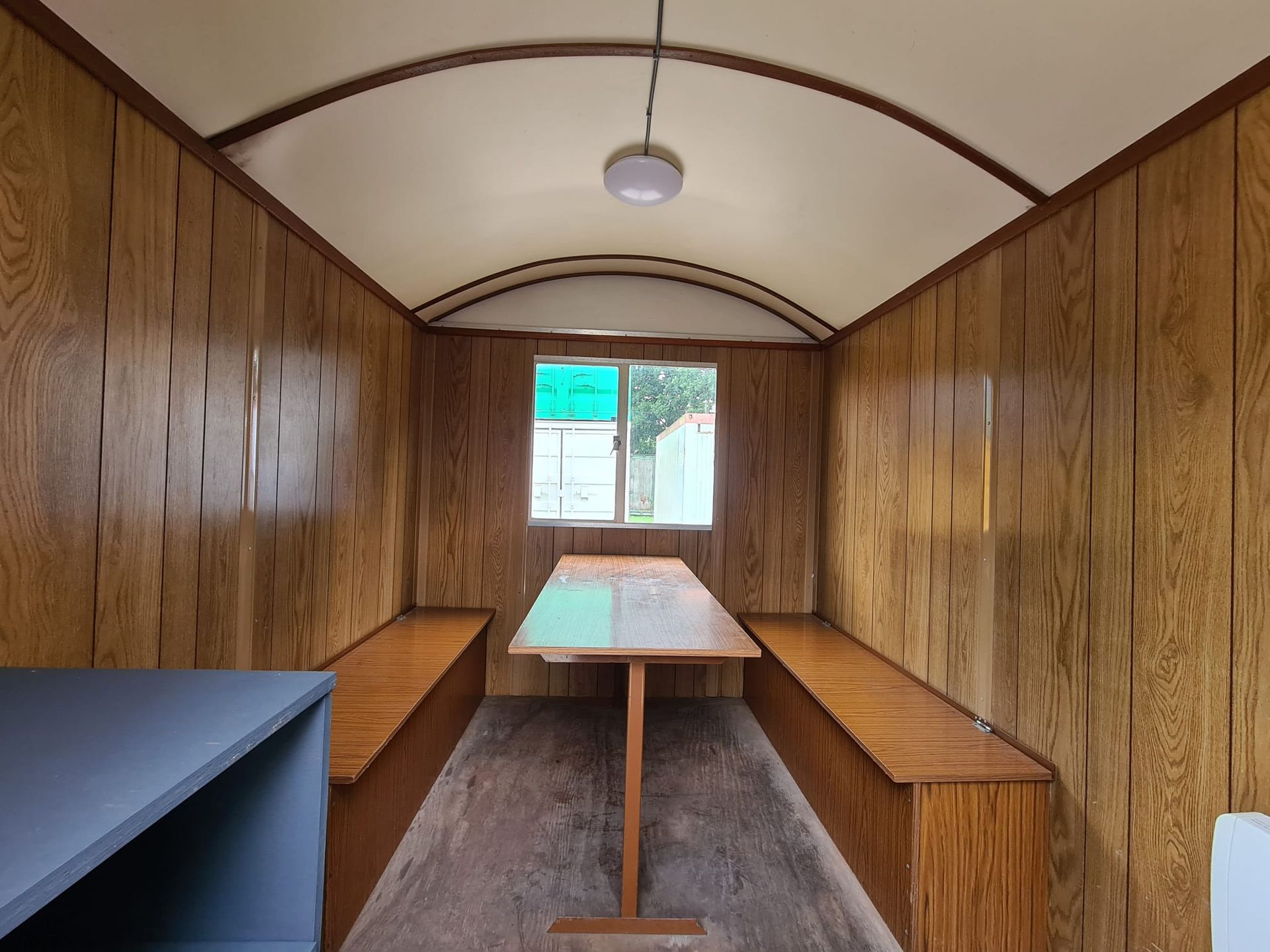 Een kamer met een tafel en banken erin