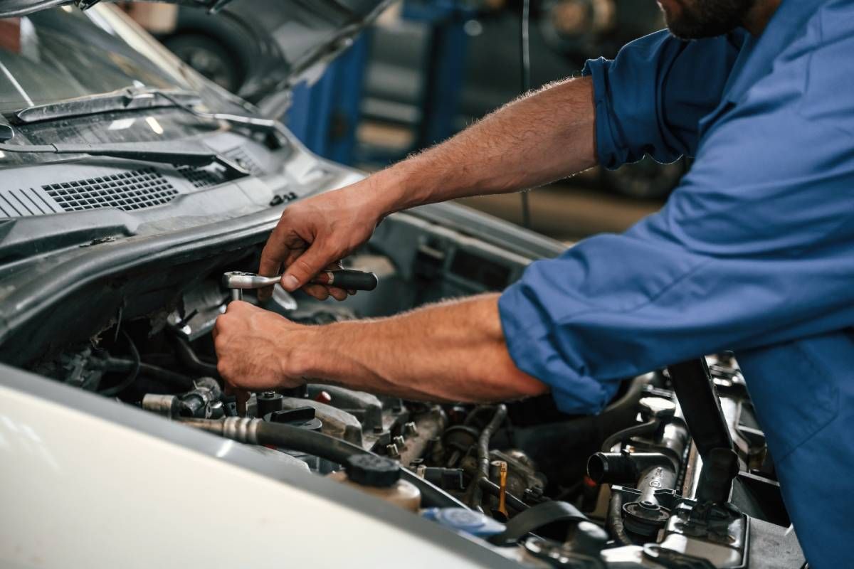An auto mechanic performing transmission services on a car near Sharonville, OH