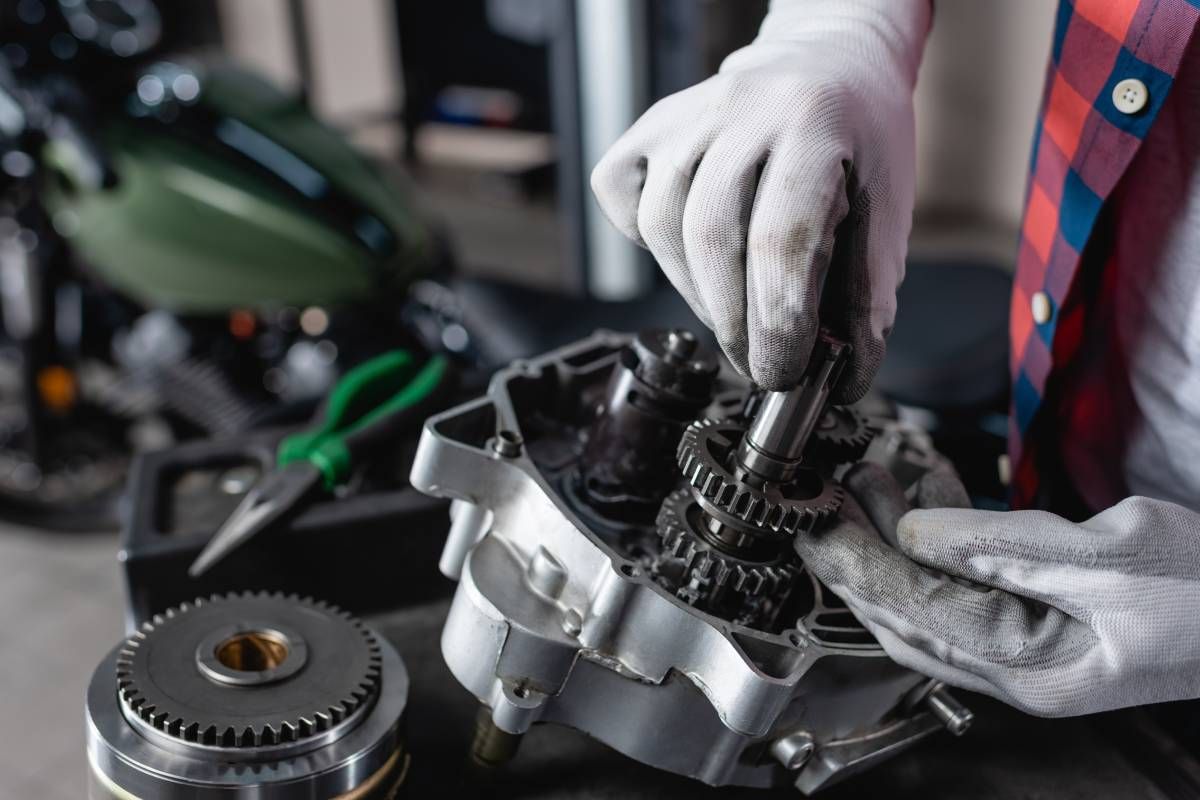 Mechanic holding a part of a disassembled car transmission near Cincinnati, OH
