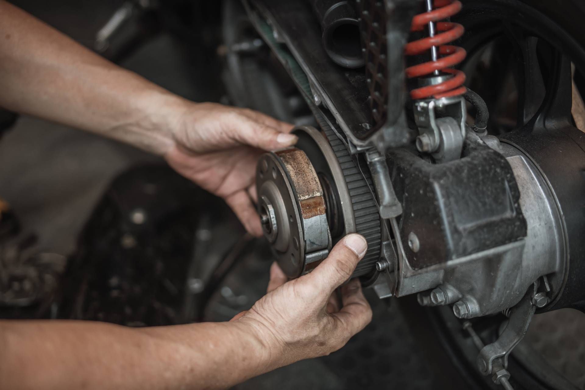 Mechanic holding a transmission during CVT maintenance.