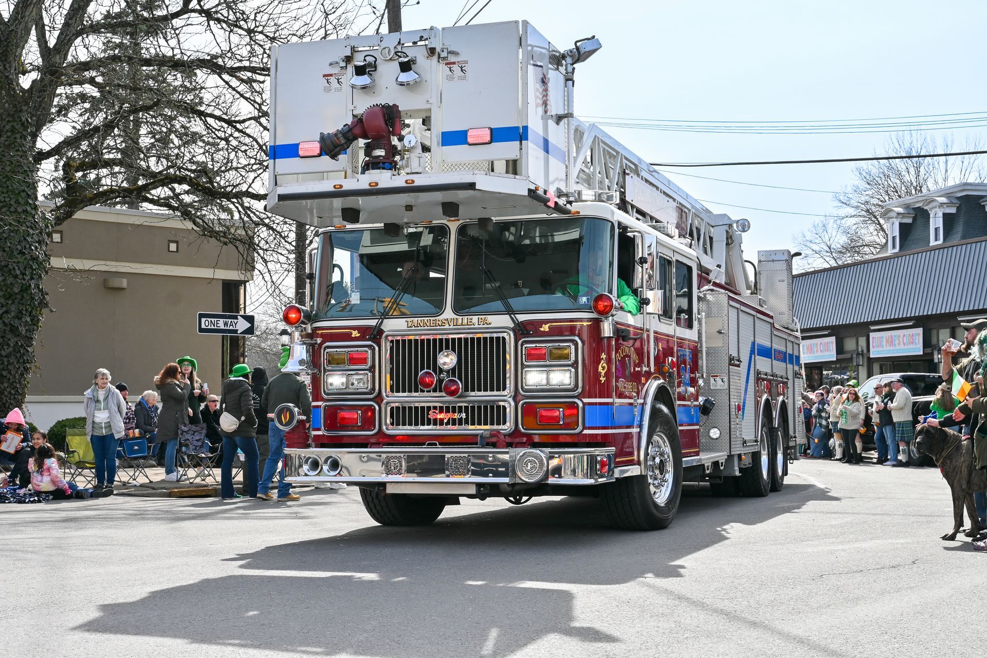 A fire truck is driving down a street in a parade.