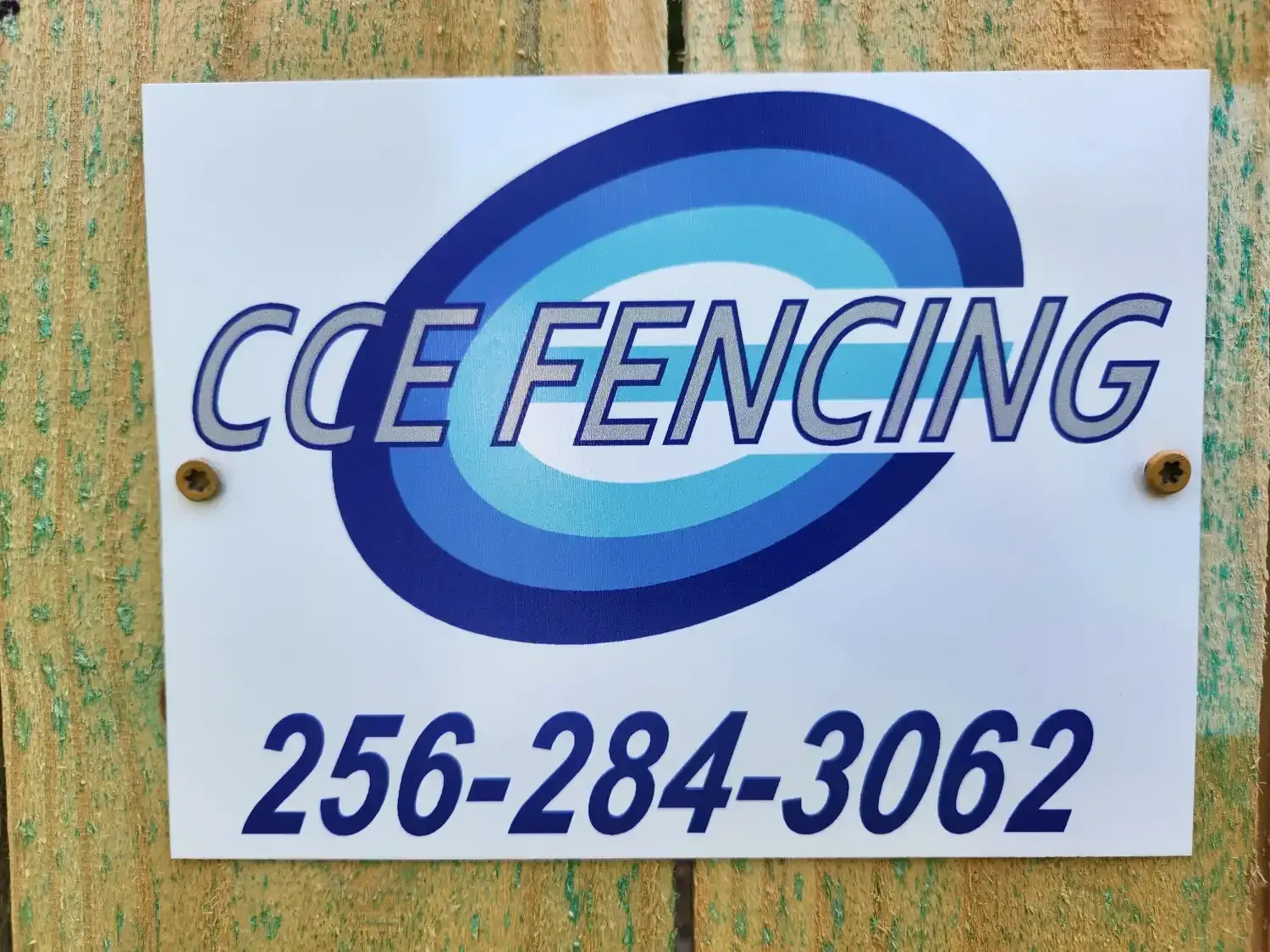 CCE Fencing sign with blue logo and phone number 256-284-3062
