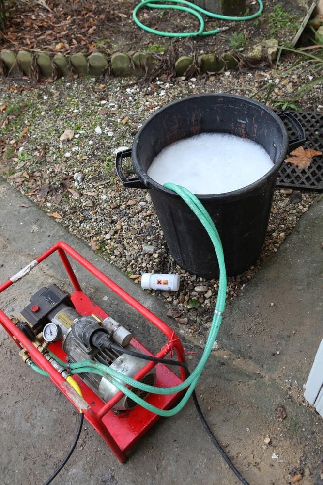 A Black Bucket Filled with White Liquid Is Connected to A Green Hose — Natraspray Lismore in Ballina, NSW