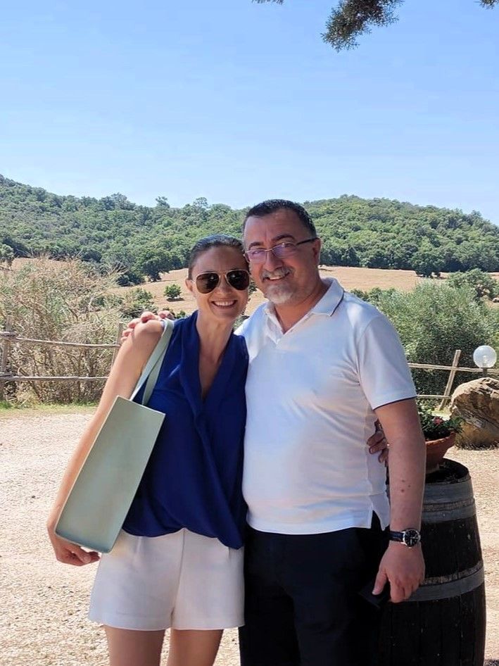 Owners of Agriturismo Lo Scalandrino, in Tuscany, cheerfully enjoying the  scenic olive groves and rolling hills.