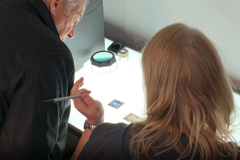 A man and woman looking at photos on a table