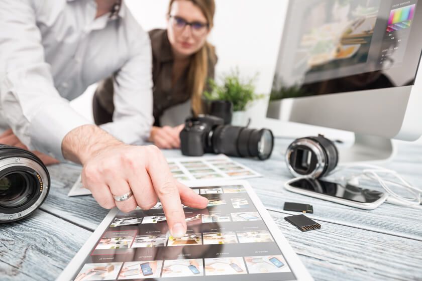 A man and woman looking at photos on a table