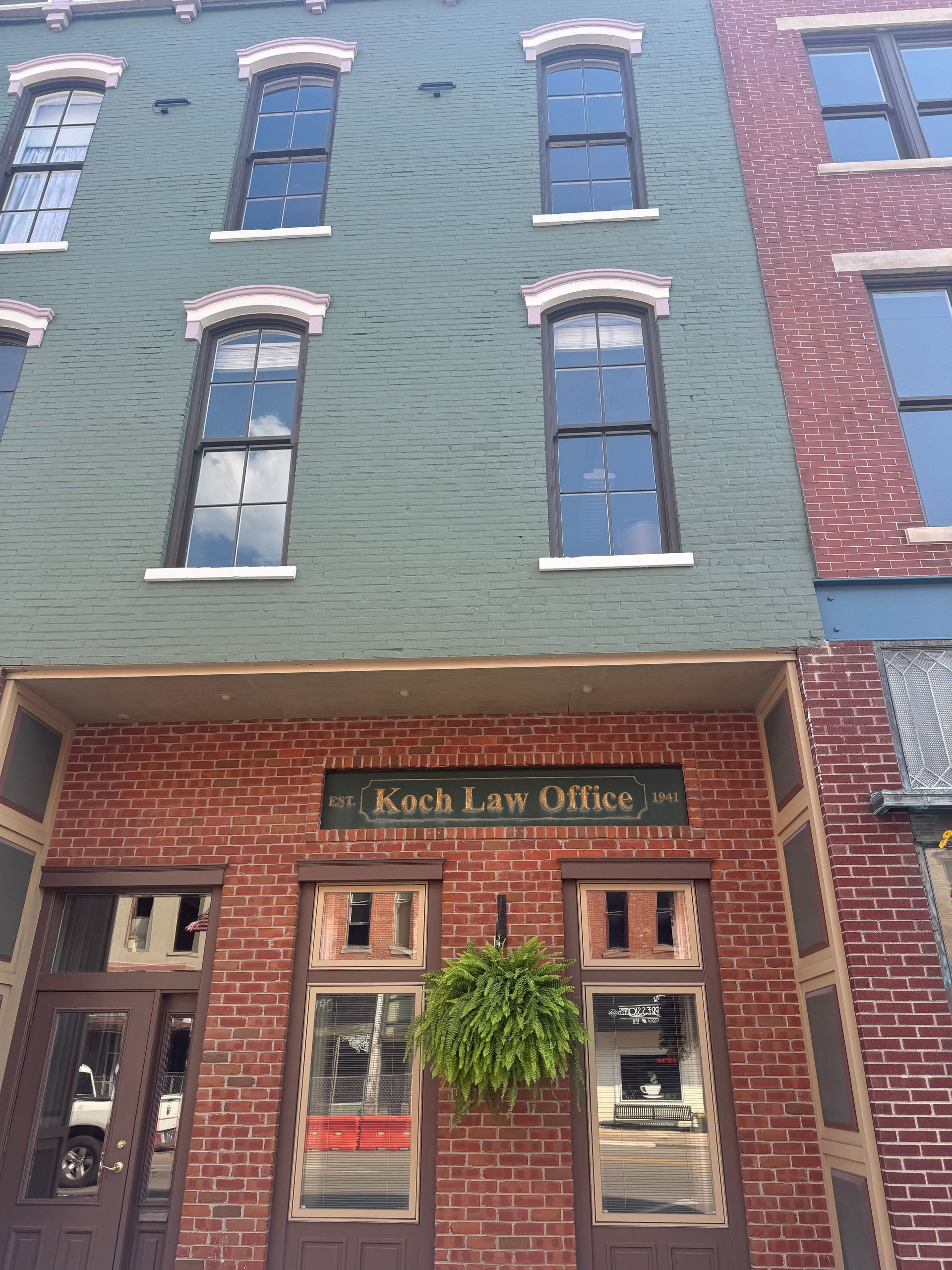 A brick building with a sign that says koch law office