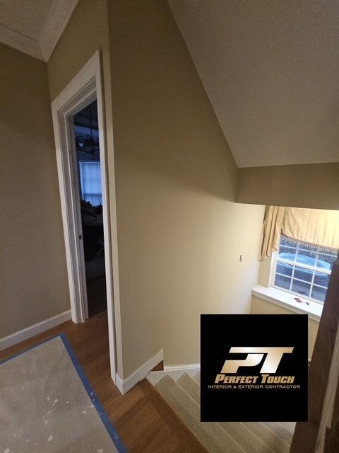 A hallway with stairs and a perfect touch logo