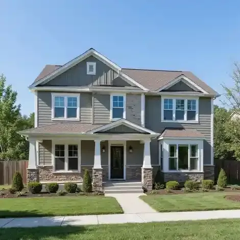 Two-story house with green siding, stone accents, and a front porch on a sunny day.