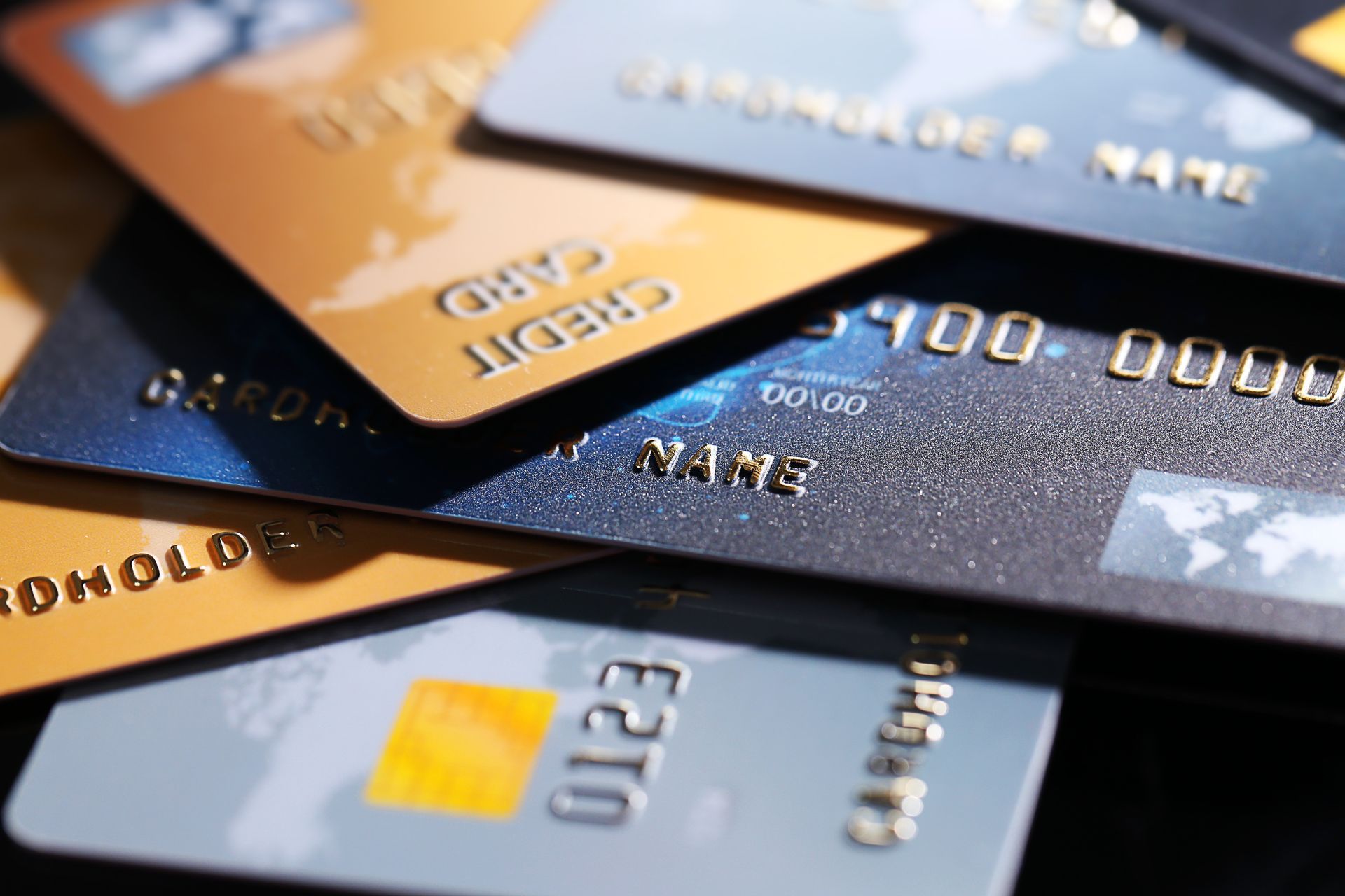 Pile of credit cards, various colors and designs, partially overlapping.