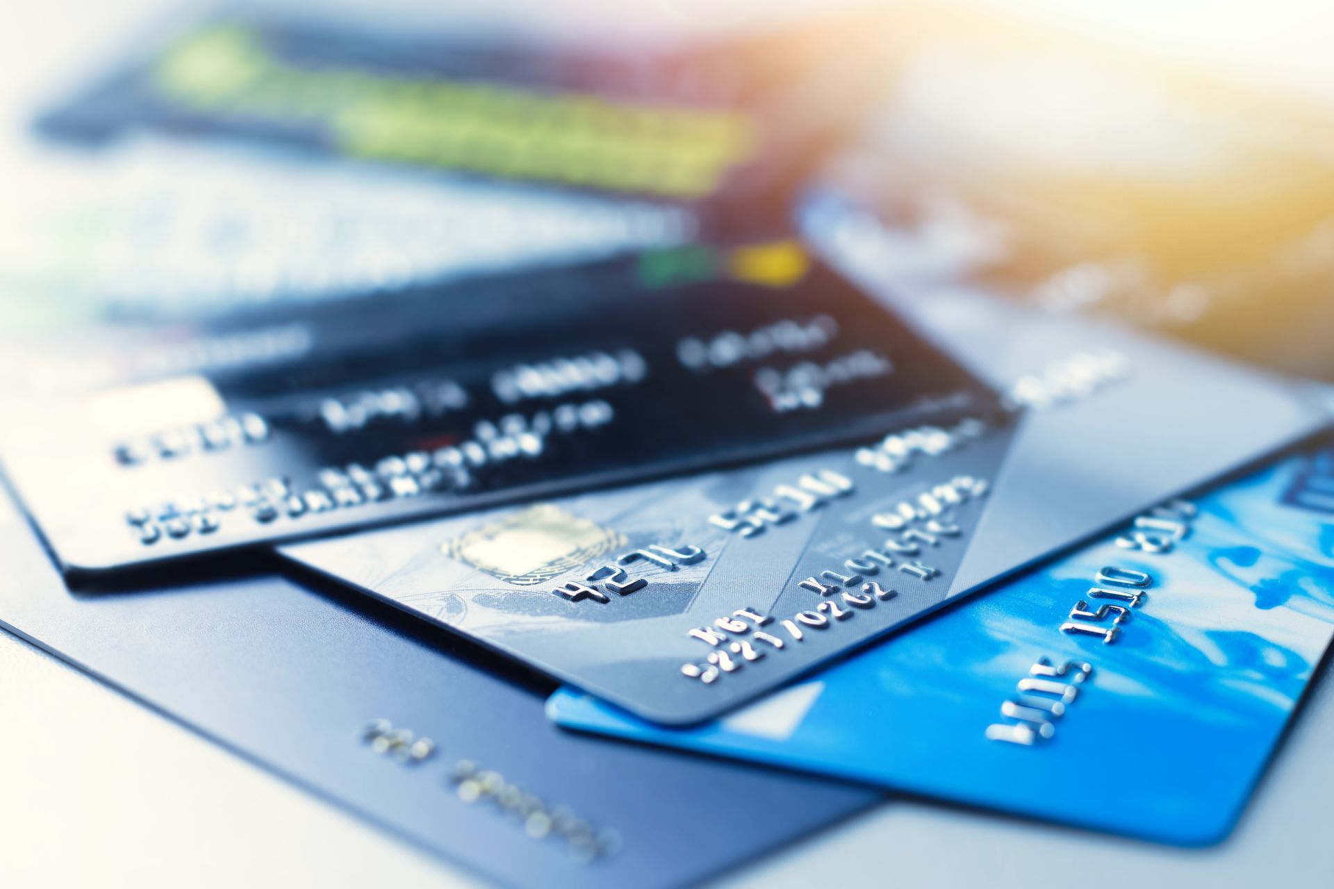 Pile of credit cards, various colors and designs, suggesting financial transactions.