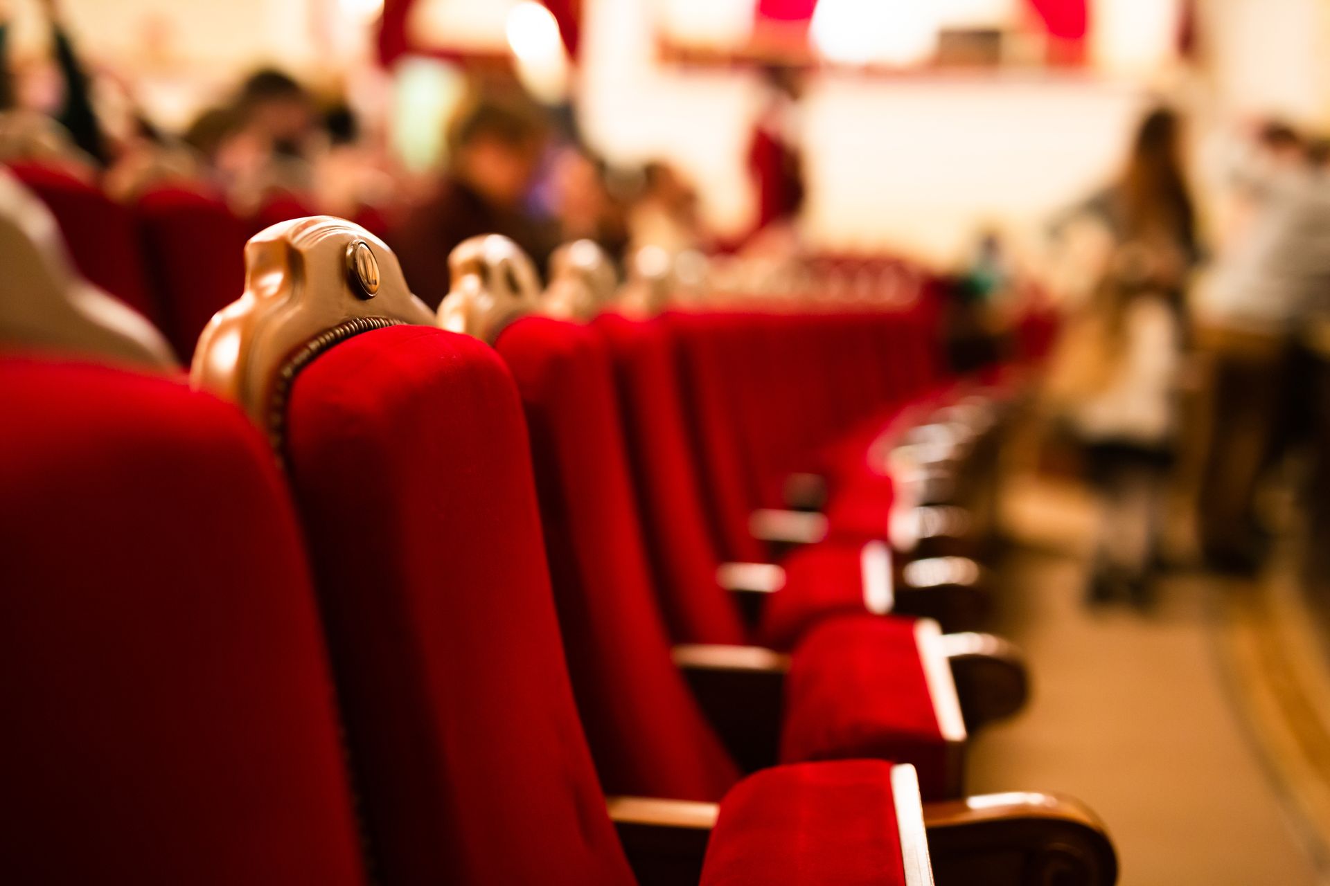 a close up shot of a theater and red velvet chairs