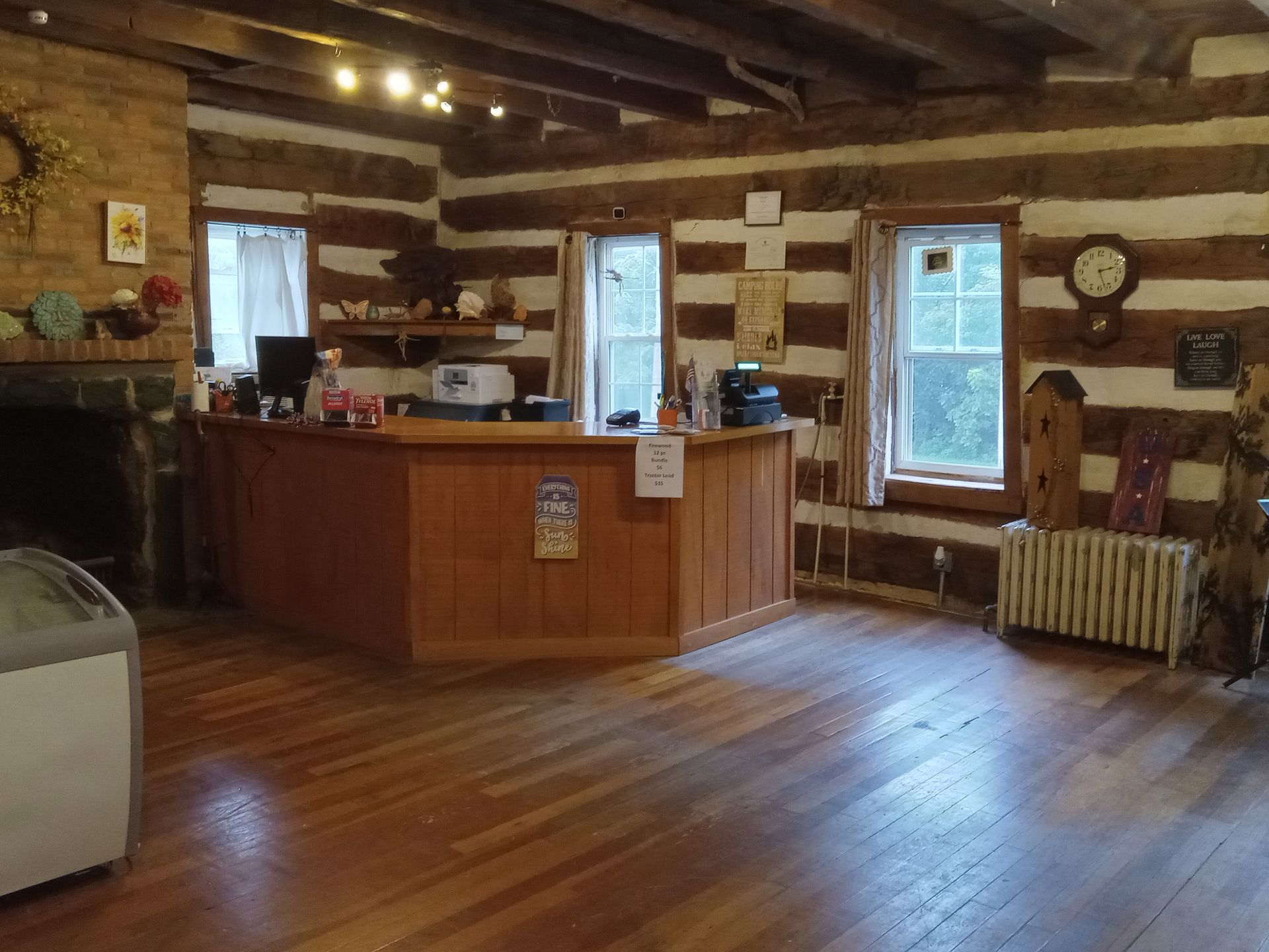 A log cabin with a reception desk and a fireplace