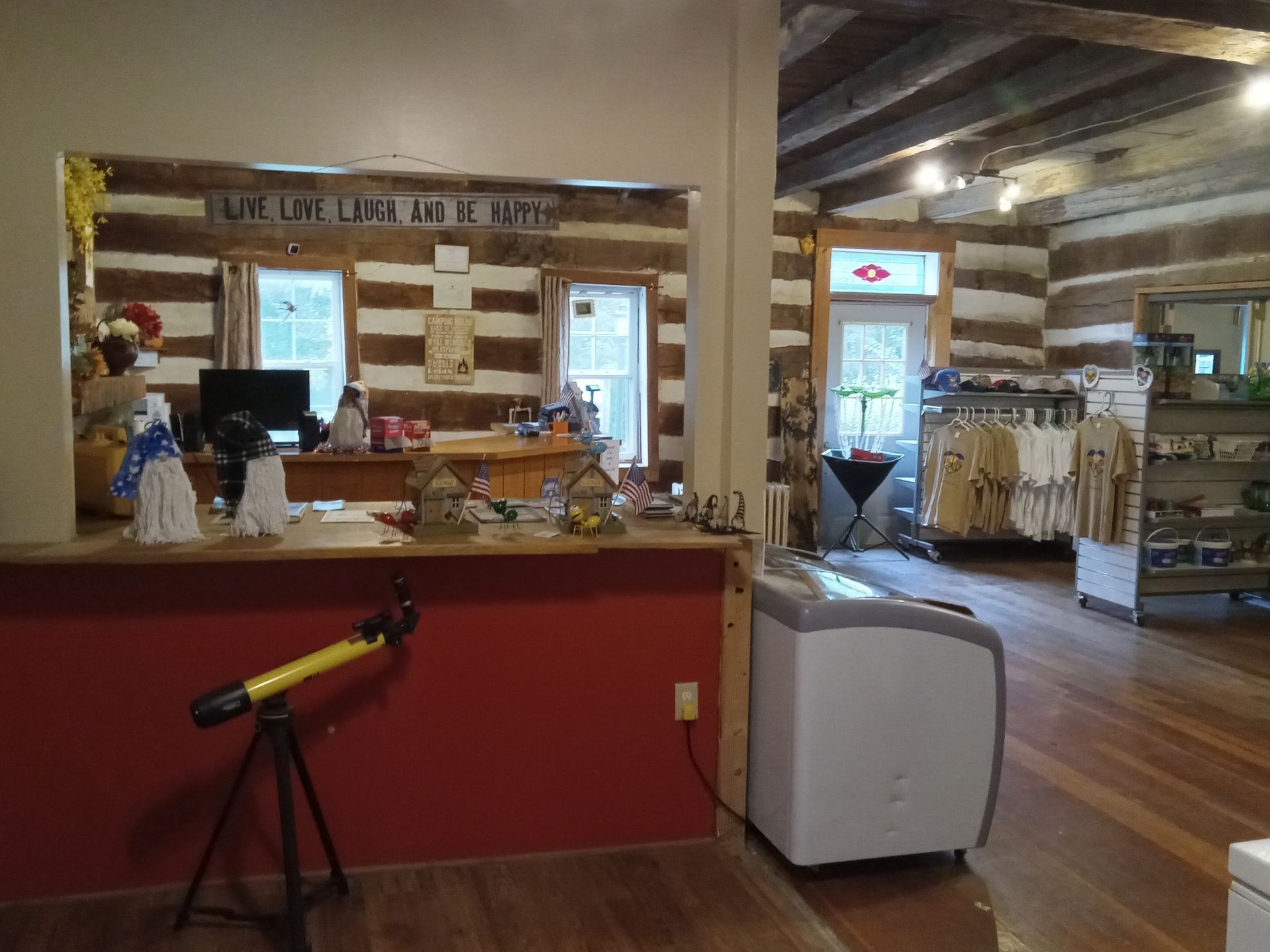 A telescope is sitting in front of a counter in a store.
