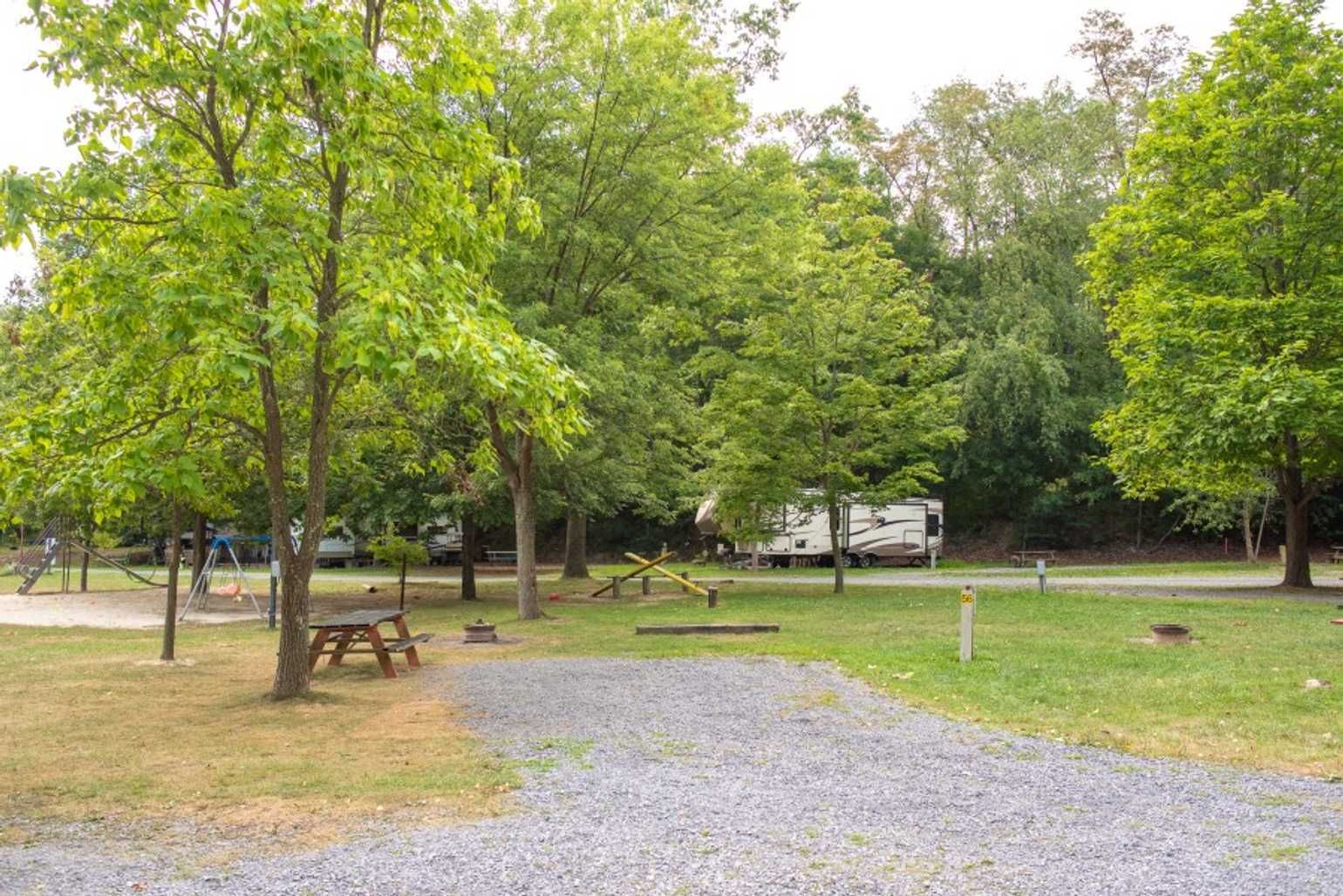 A park with trees and a picnic table in the middle