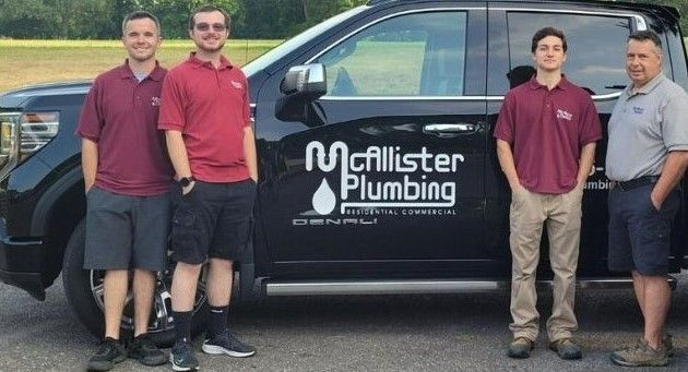 Four Employees Near Truck With Hands in Pockets — Glen Burnie, MD — McAllister Plumbing Inc.