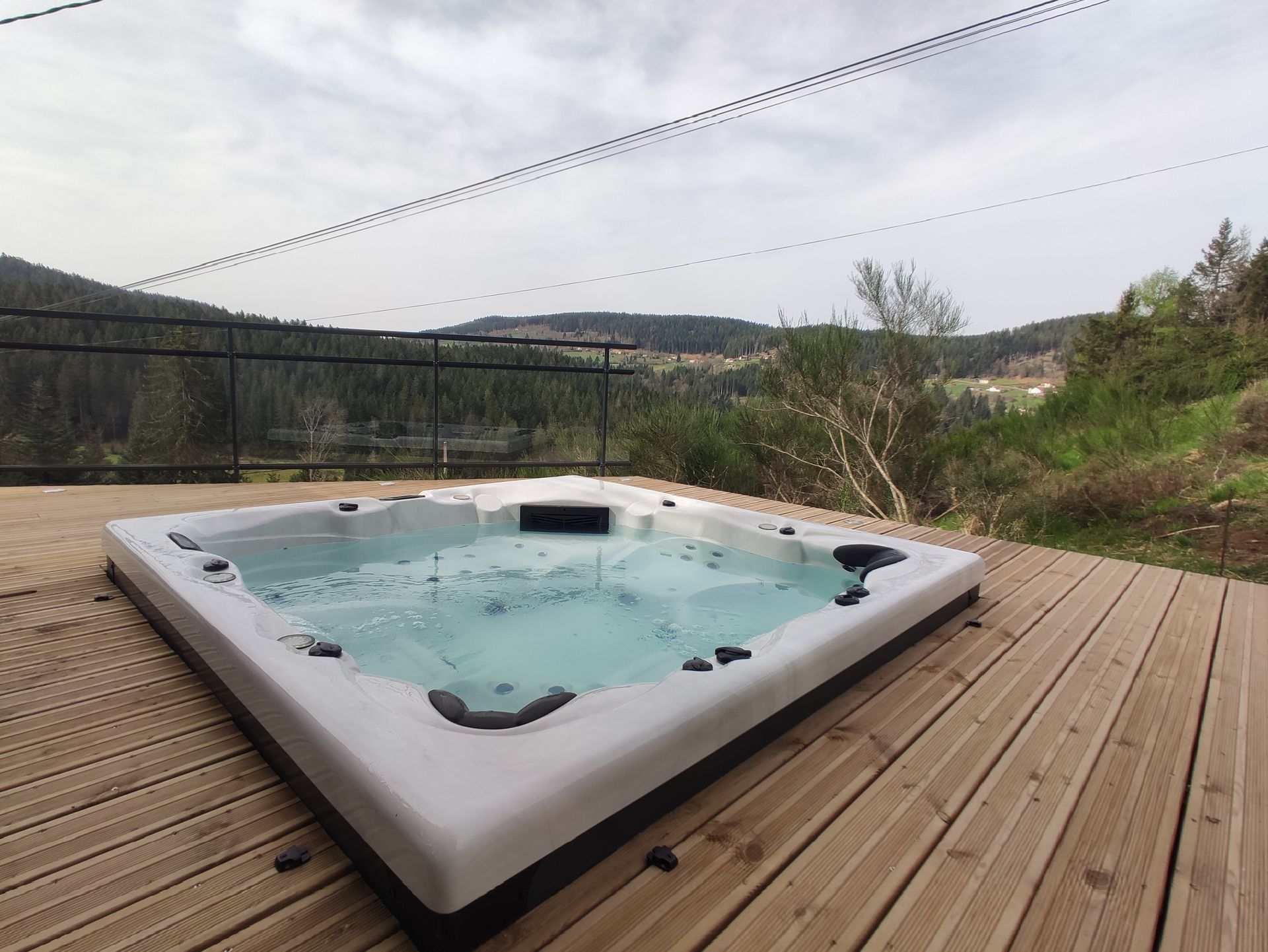 Un bain à remous est posé sur une terrasse en bois.