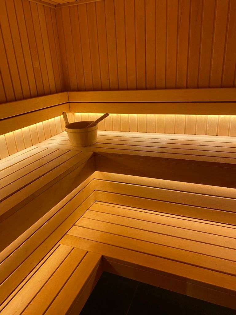 Un sauna en bois avec un seau en bois sur le banc.