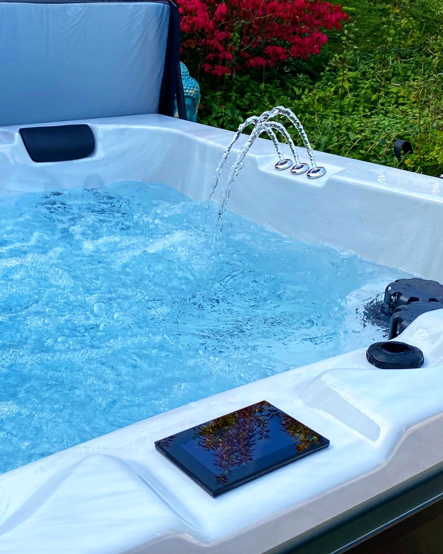 Un jacuzzi blanc avec de l'eau bleue et une fontaine