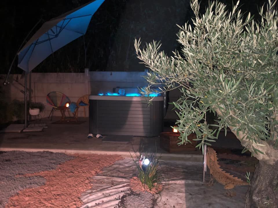 Un bain à remous est éclairé la nuit dans une cour arrière.
