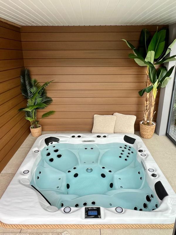 Un bain à remous est installé dans une pièce à côté d'une plante.