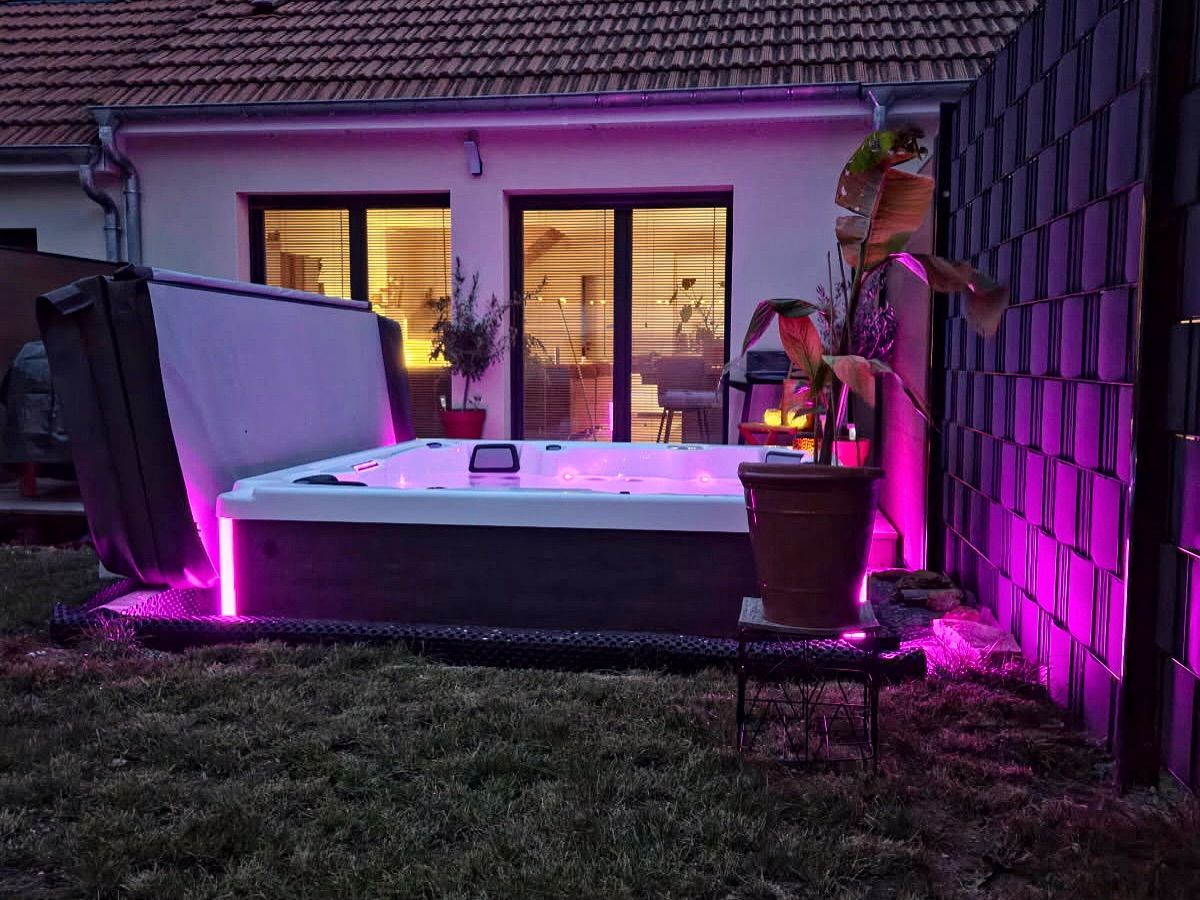 spa à l'arrière d'une maison éclairé par un néon rose