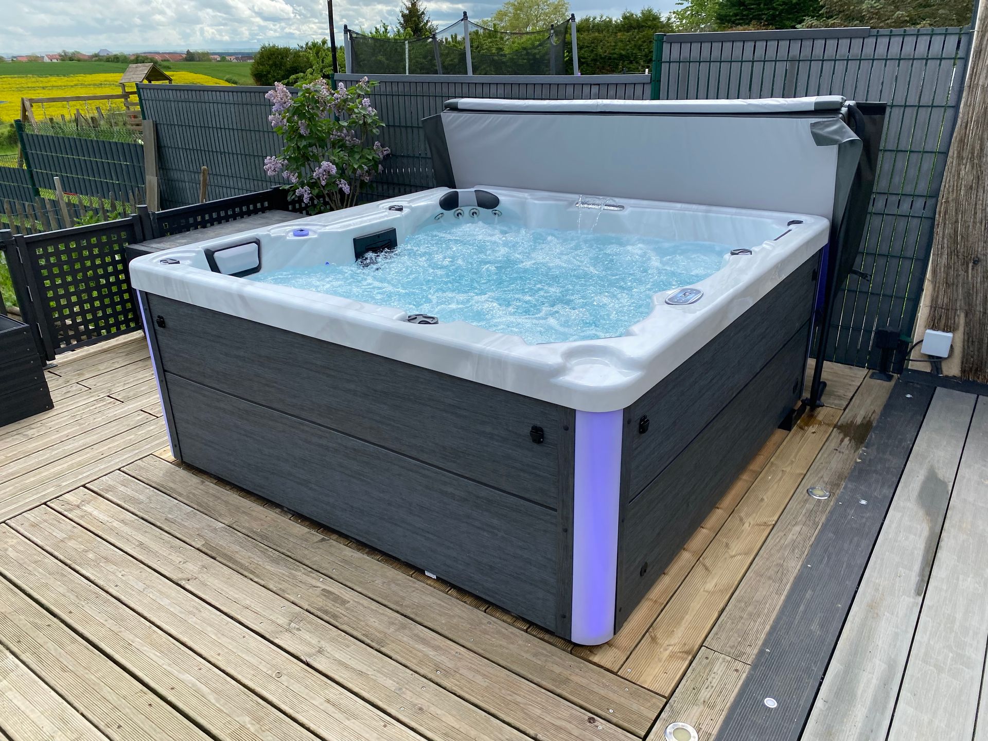Un bain à remous est posé sur une terrasse en bois.