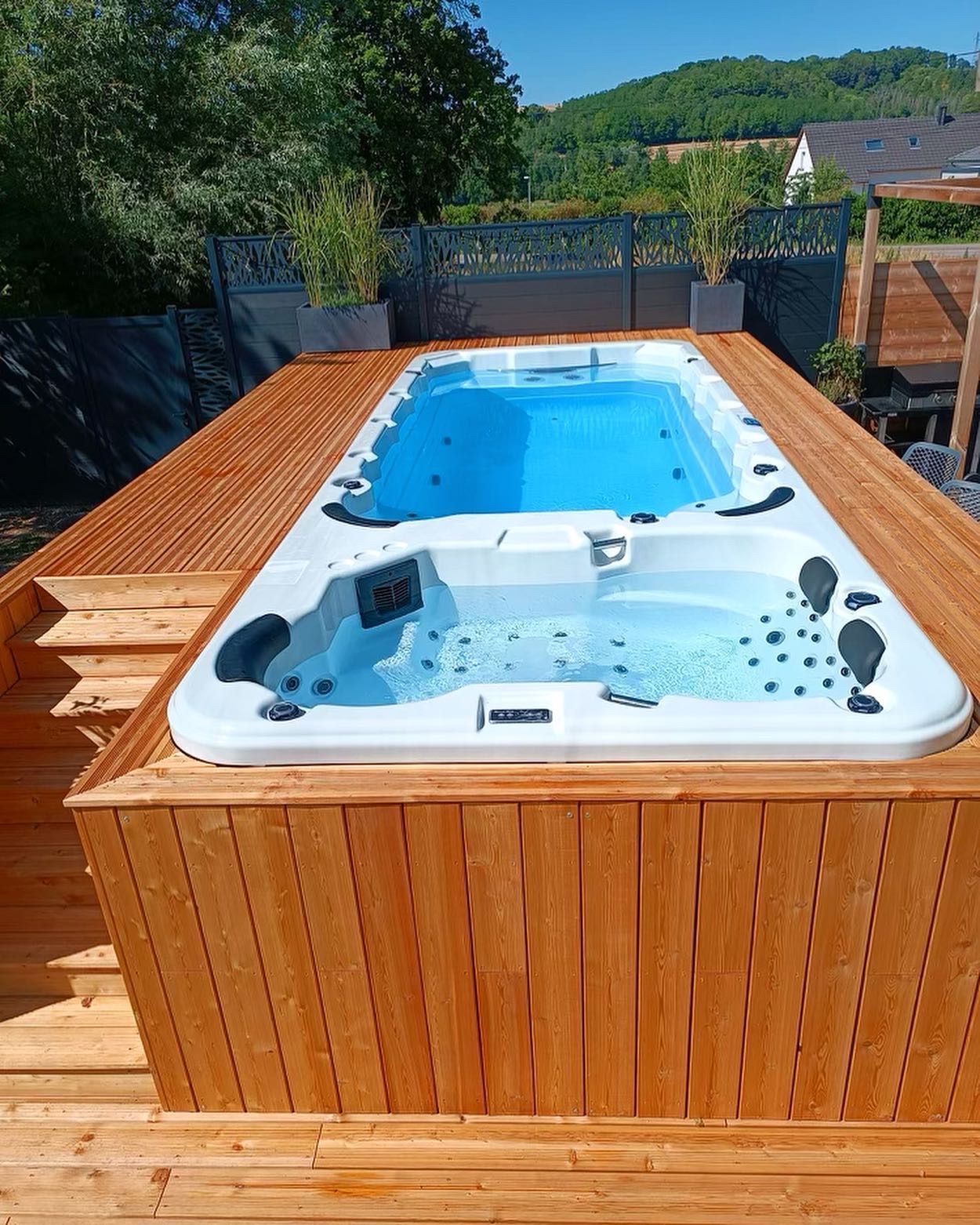 Un bain à remous est posé sur une terrasse en bois.