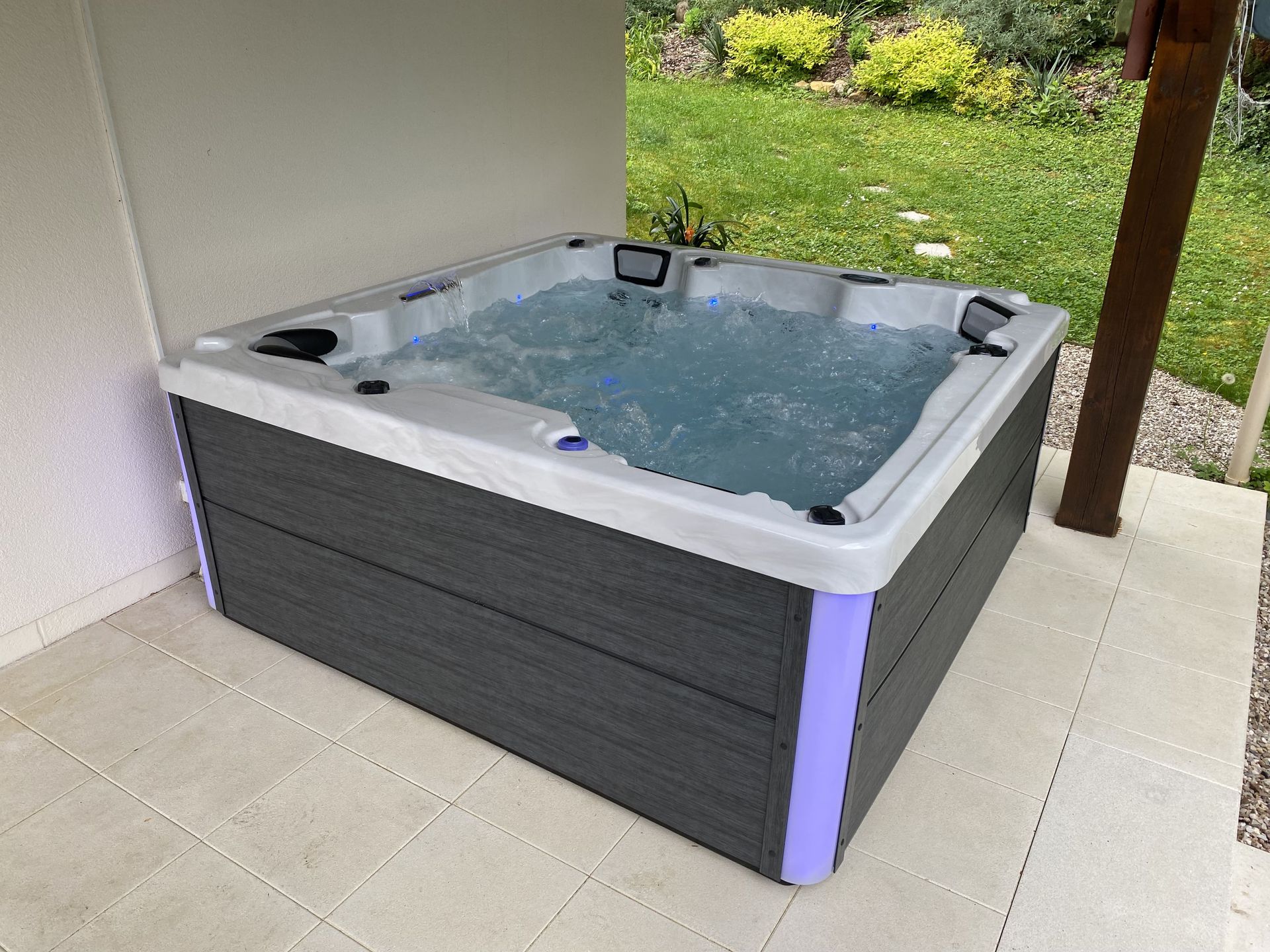Un bain à remous est posé sur un sol carrelé à l'extérieur.