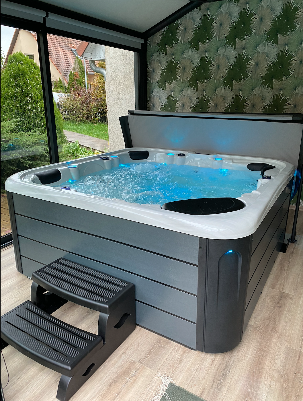 Un grand bain à remous est installé dans une pièce à côté d'une fenêtre.
