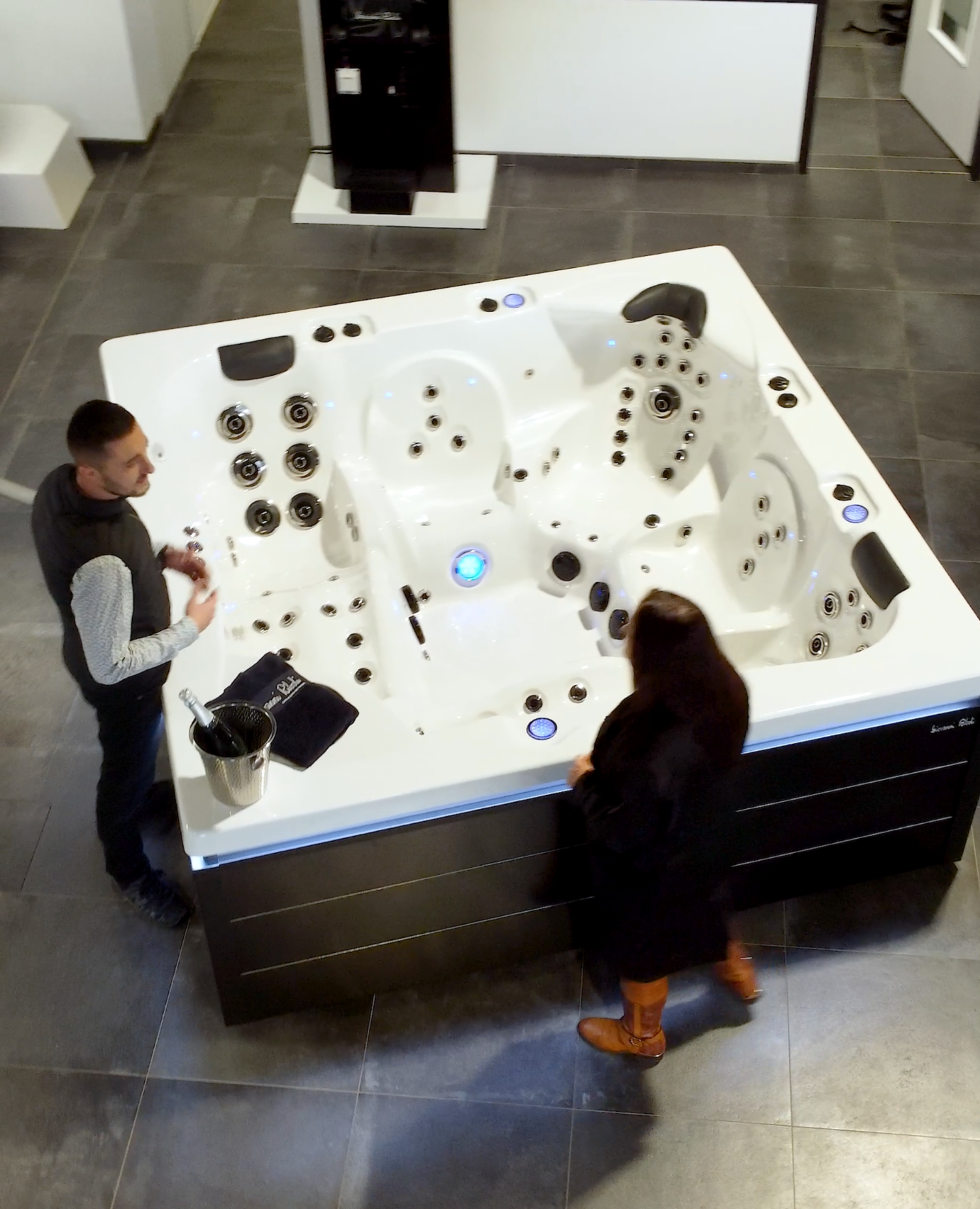 Un homme et une femme se tiennent devant un jacuzzi