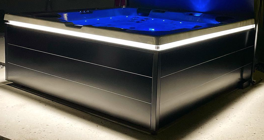 Un jacuzzi noir avec des lumières bleues dessus