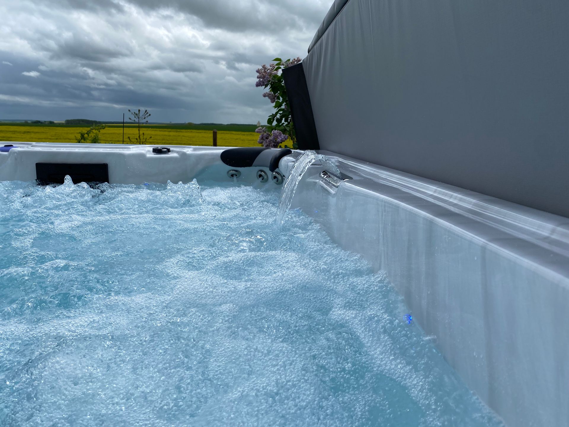 Un jacuzzi avec des bulles qui en sortent et un champ en arrière-plan.
