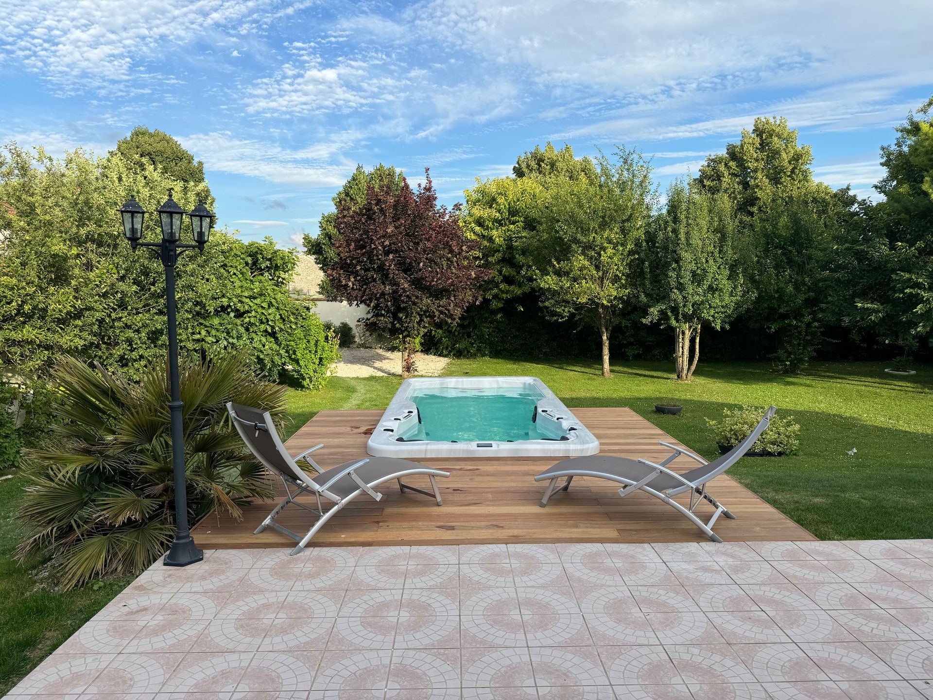 Un bain à remous est posé sur une terrasse en bois dans une cour arrière.