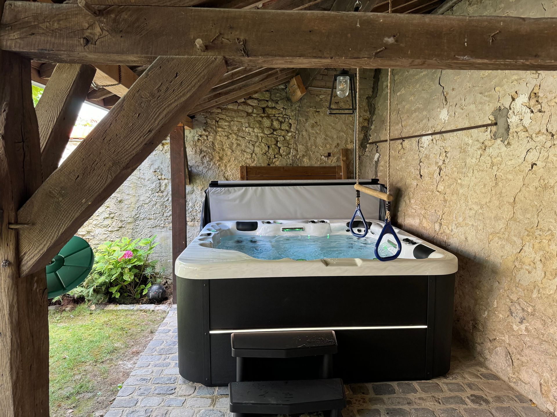 Un bain à remous est placé sous une structure en bois.