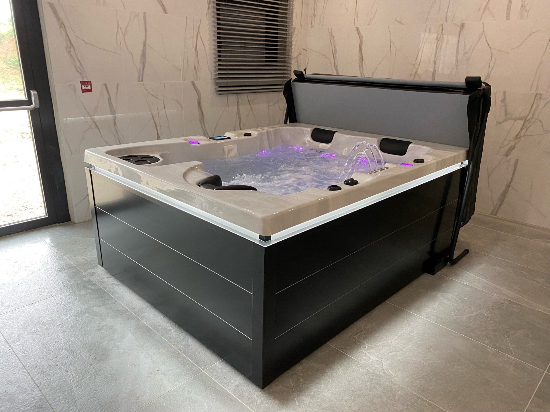 Un bain à remous est installé dans une pièce à côté d'une fenêtre.