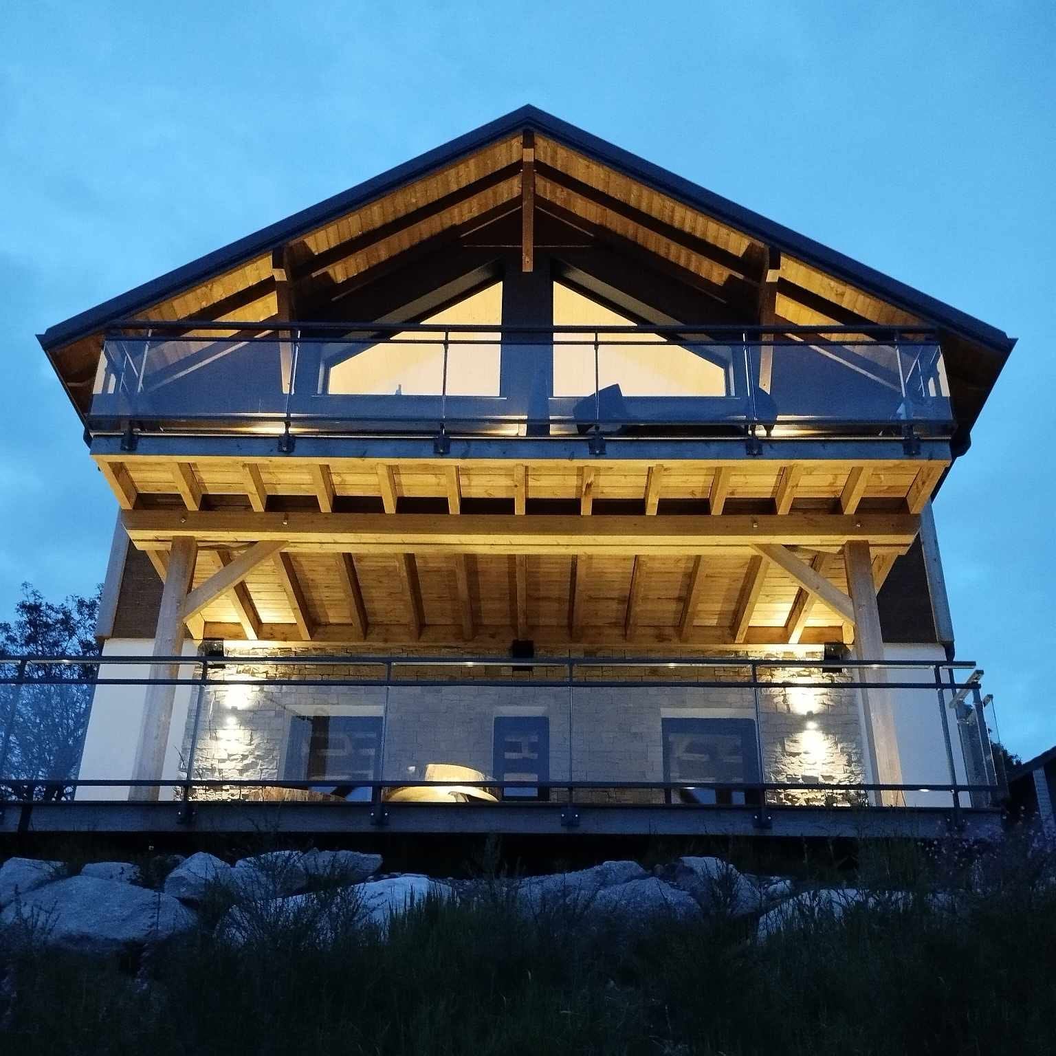 Une maison avec un balcon est éclairée la nuit