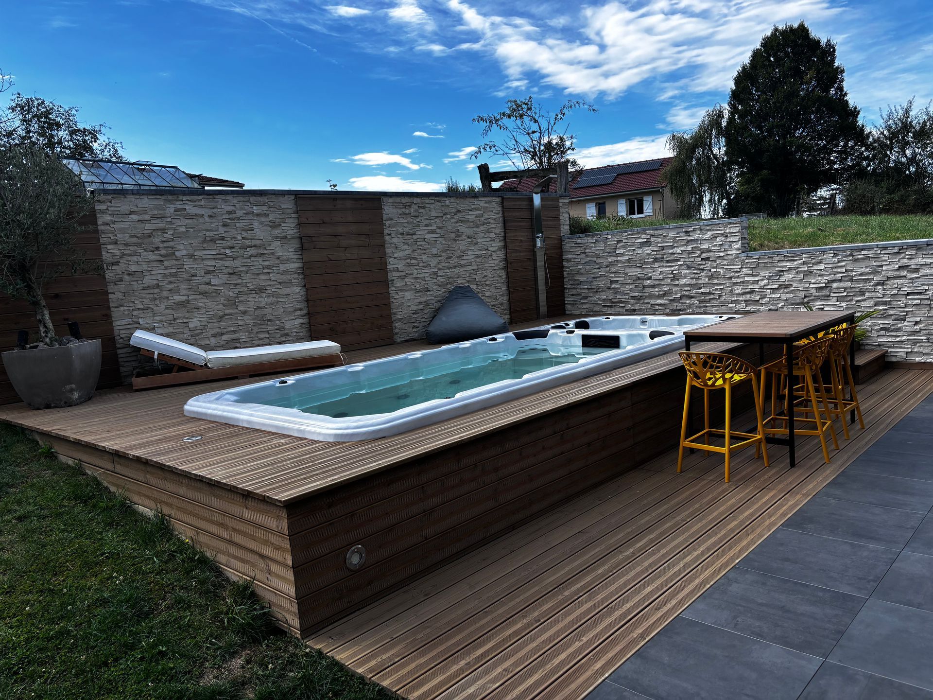 Une piscine avec une table et des chaises dans l'arrière-cour
