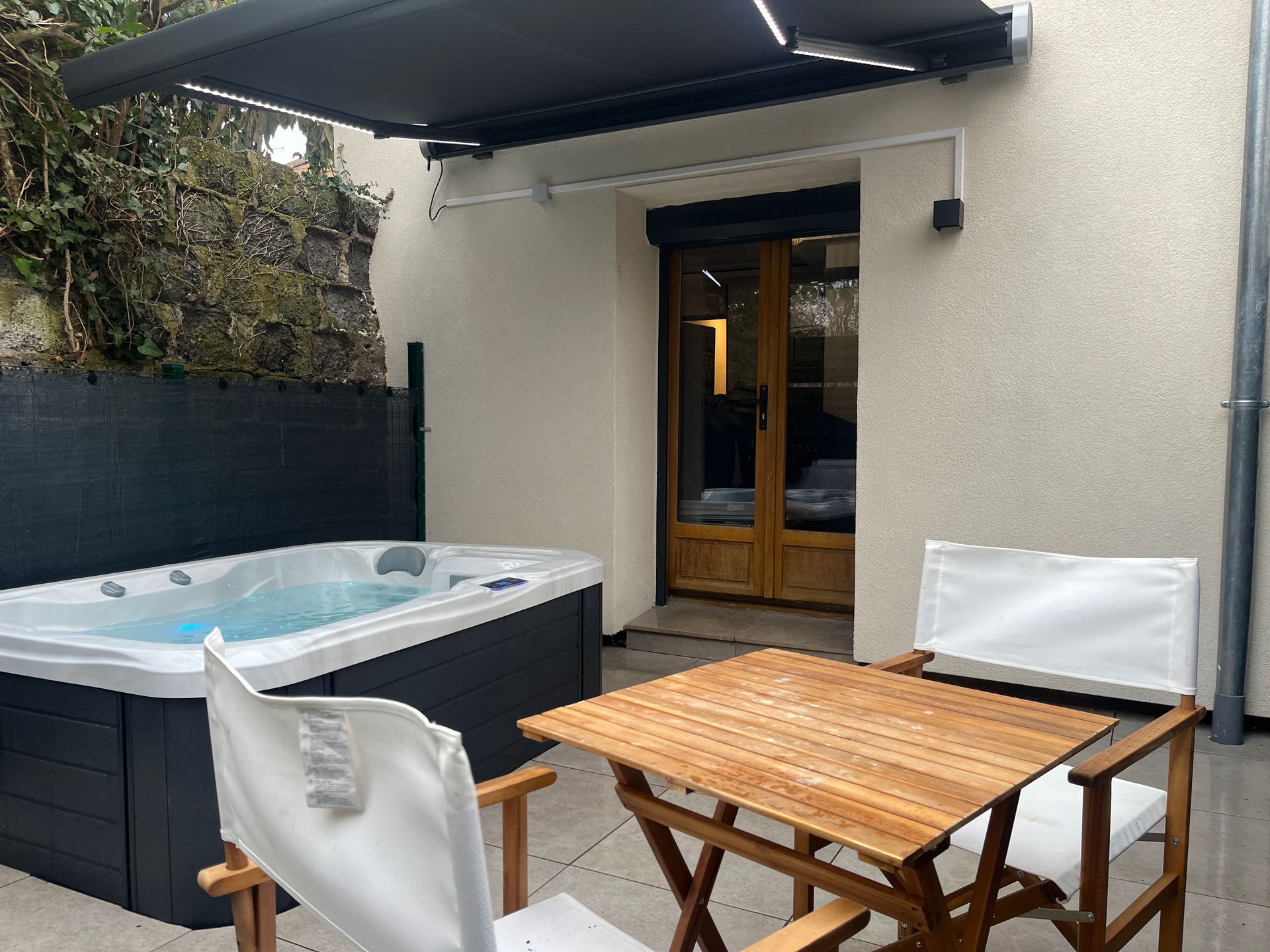 Il y a une table et des chaises devant un bain à remous.