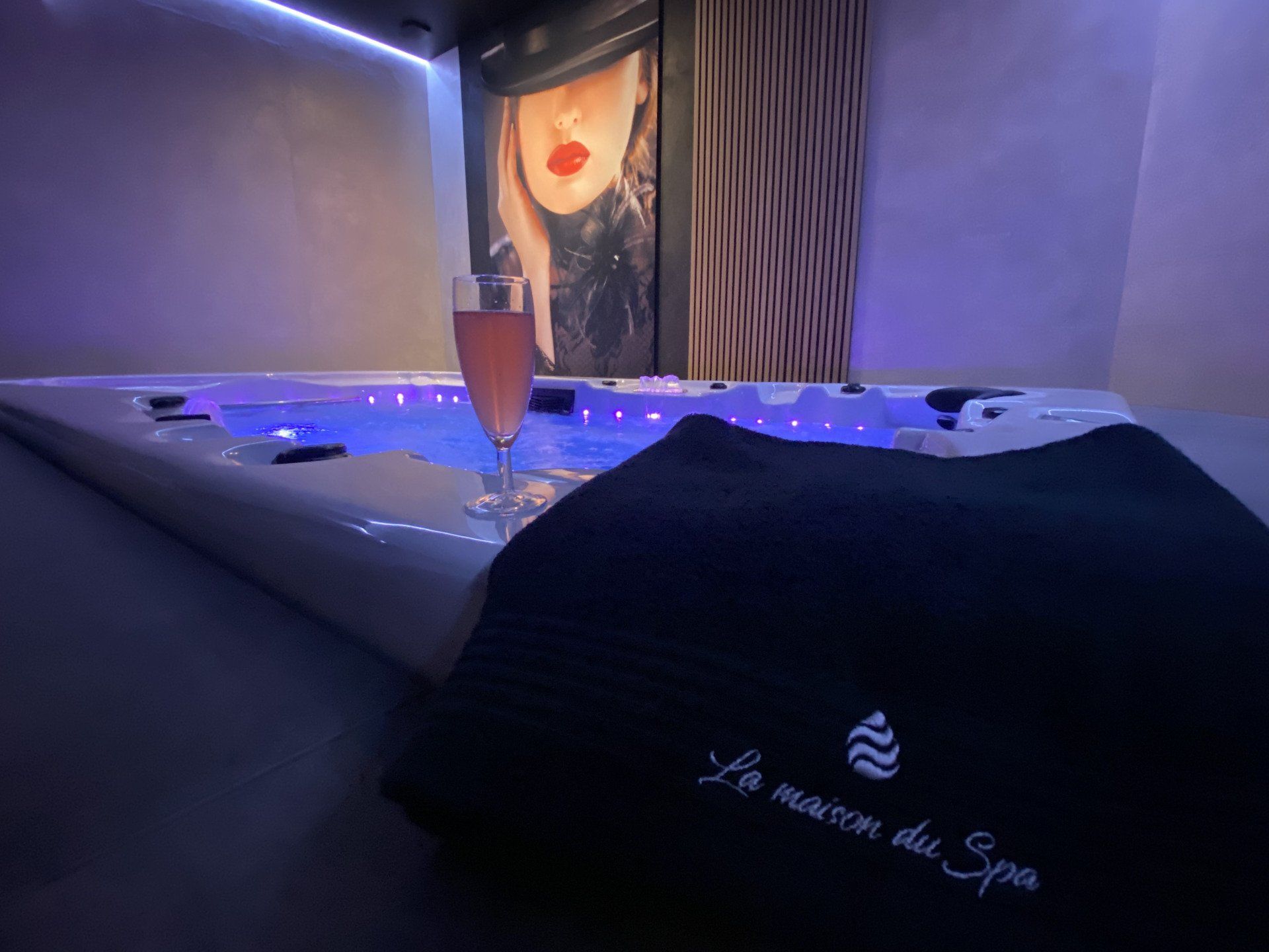 Un verre de vin est posé sur une serviette à côté d'un bain à remous.